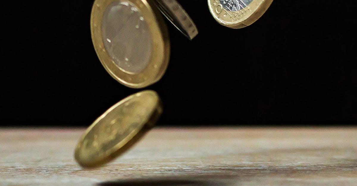 Coins falling onto a wooden table